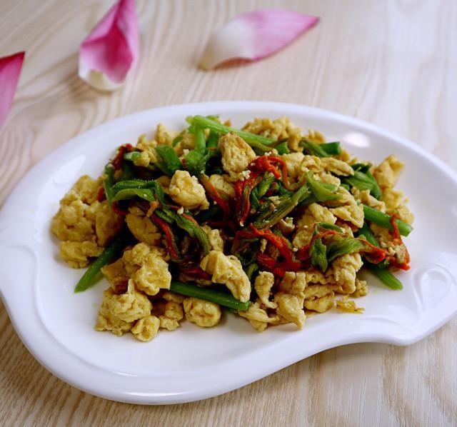 南瓜花炒蛋，黄色的花和绿色的梗搭配，成菜色彩丰富，很是养眼